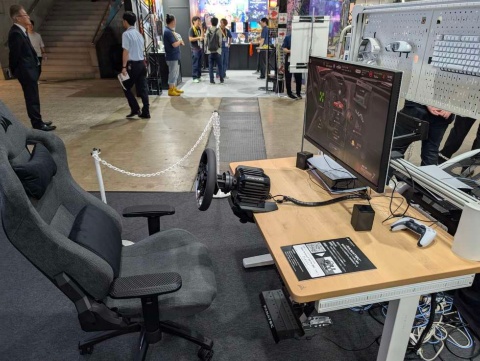 試遊台のもう1台は、日本のゲーマーを想定した環境にしているという。クランプでテーブルに挟むことでハンドルコントローラーを固定している。ダイレクトドライブ方式のハンドルコントローラーでも手軽に導入できる点をアピール