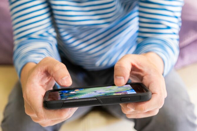 スマートフォンでゲームをする男性