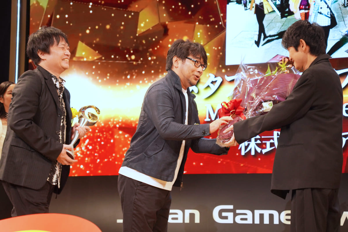 トロフィーと花束を受け取る