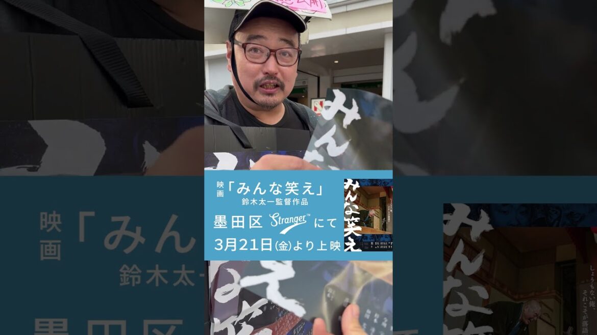 「みんな笑え」というのぼりを持った集団