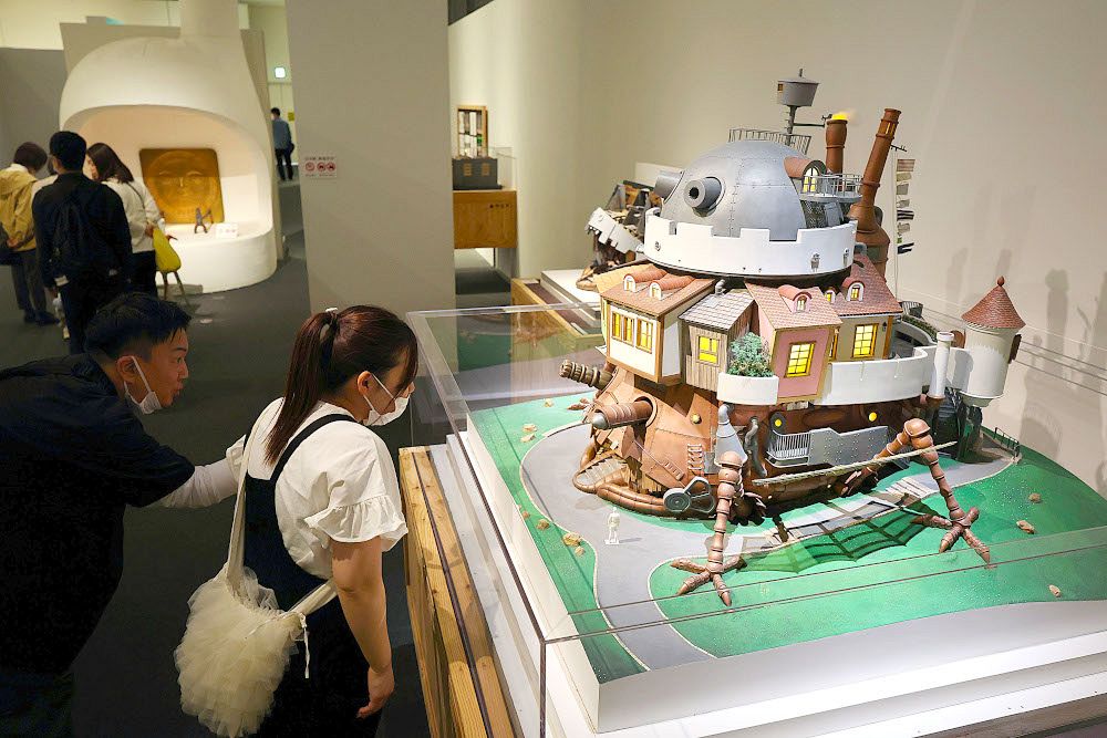 ジブリパークにある「ハウルの城」の縮小模型に見入る来場者＝岡山シティミュージアム