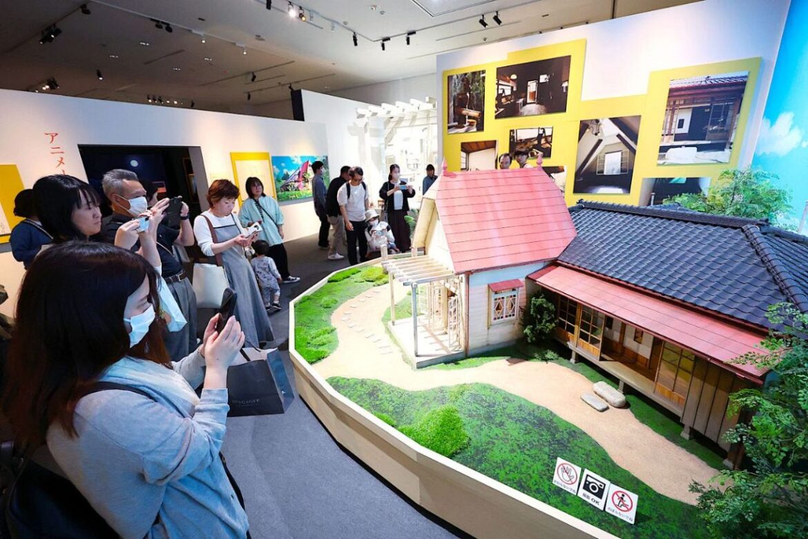 「サツキとメイの家」の縮小模型を写真に収める来場者たち＝岡山シティミュージアム