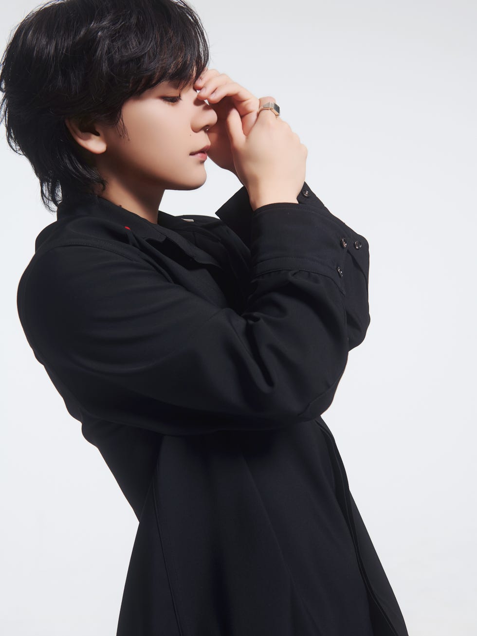 a person posing with a black coat and hands raised