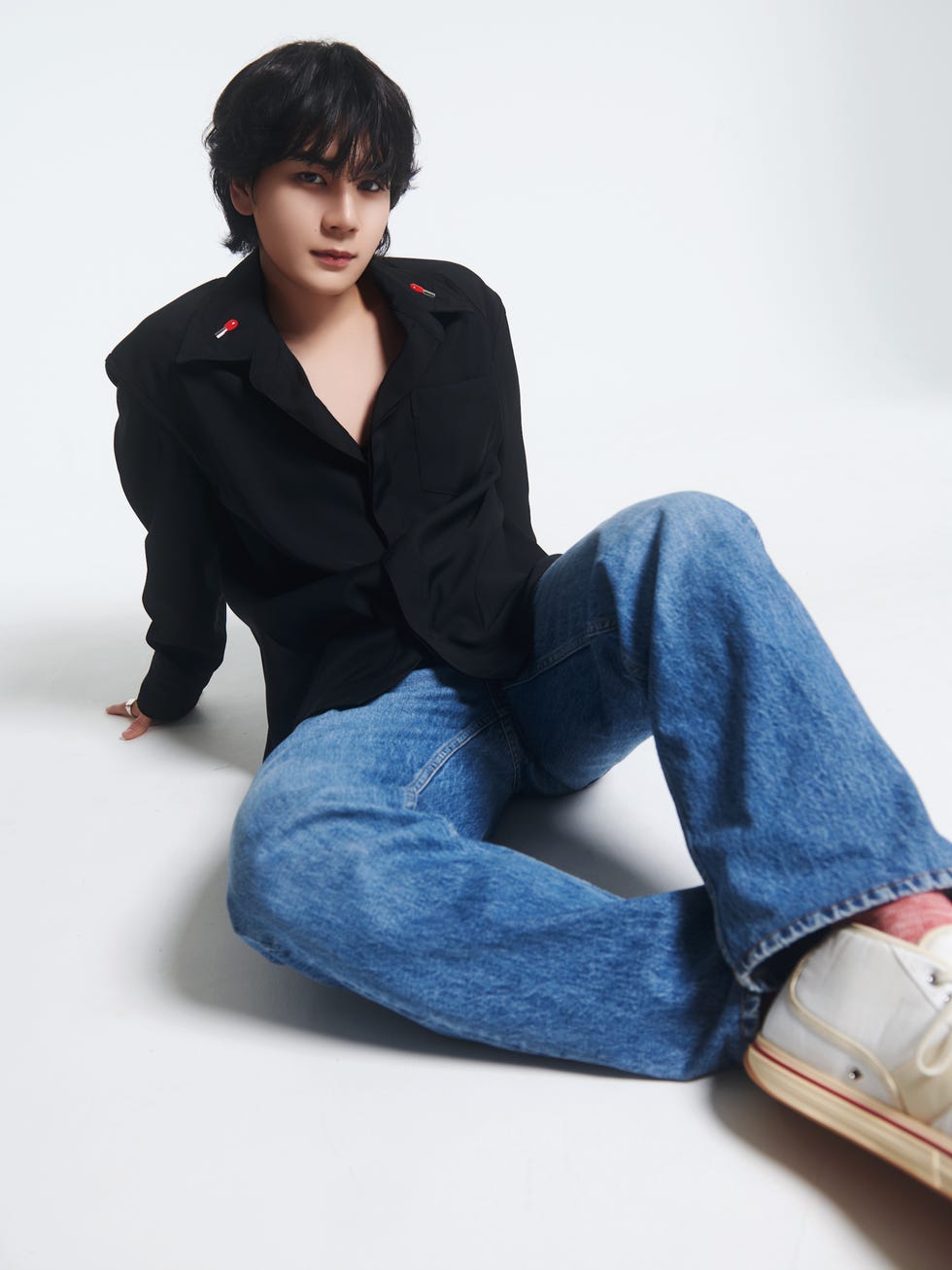 a person in a casual outfit seated on the floor