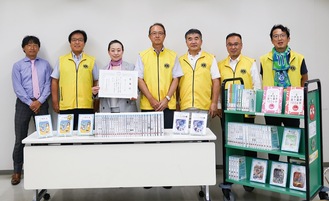 寄贈した本と並ぶ同クラブ会員ら