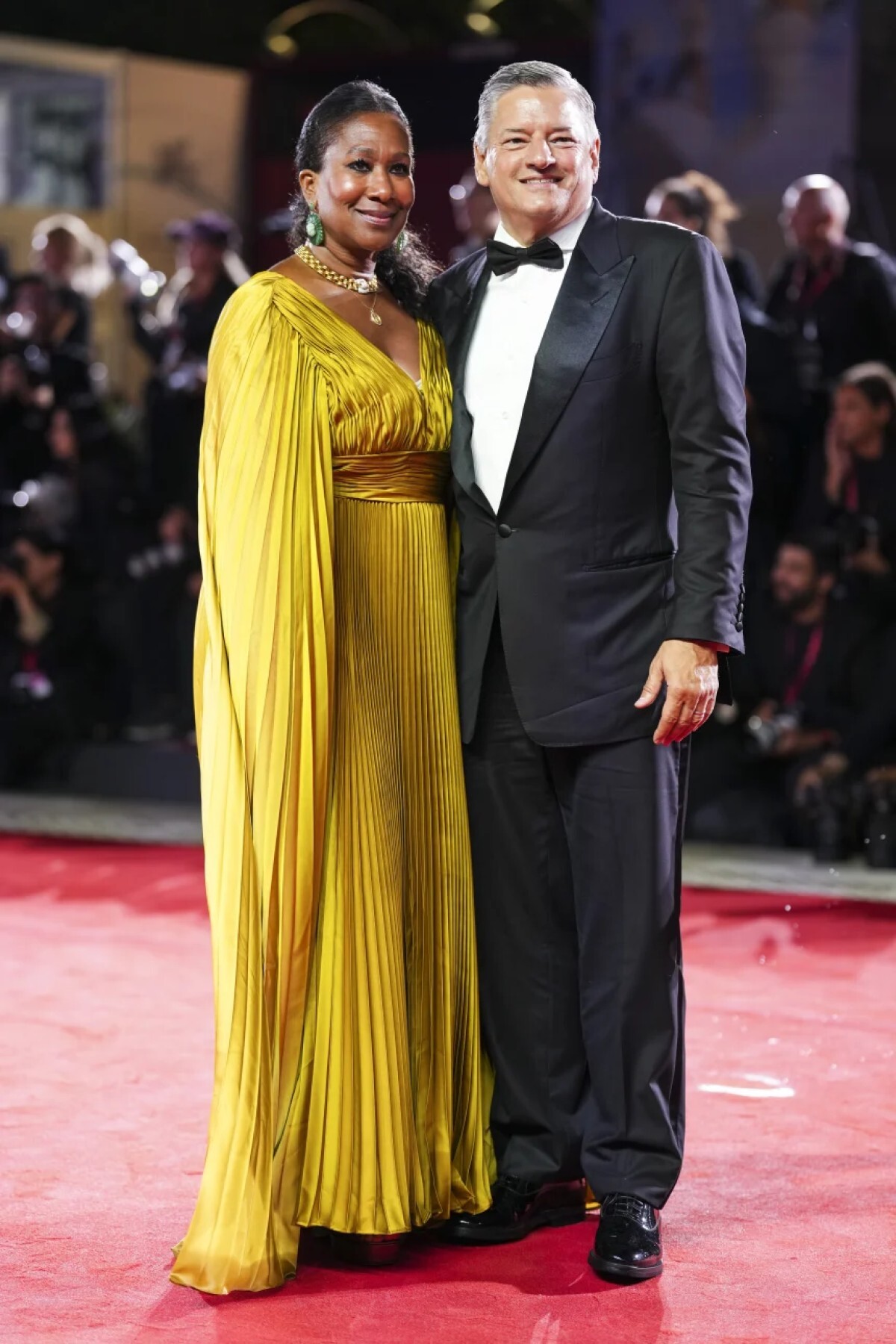 プリーツ入りのメタリックドレスを着たニコール・アバントさん(左)とクラシックな黒のタキシードを着たテッド・サランドスさん(右)/Scott A. Garfitt/Invision/AP