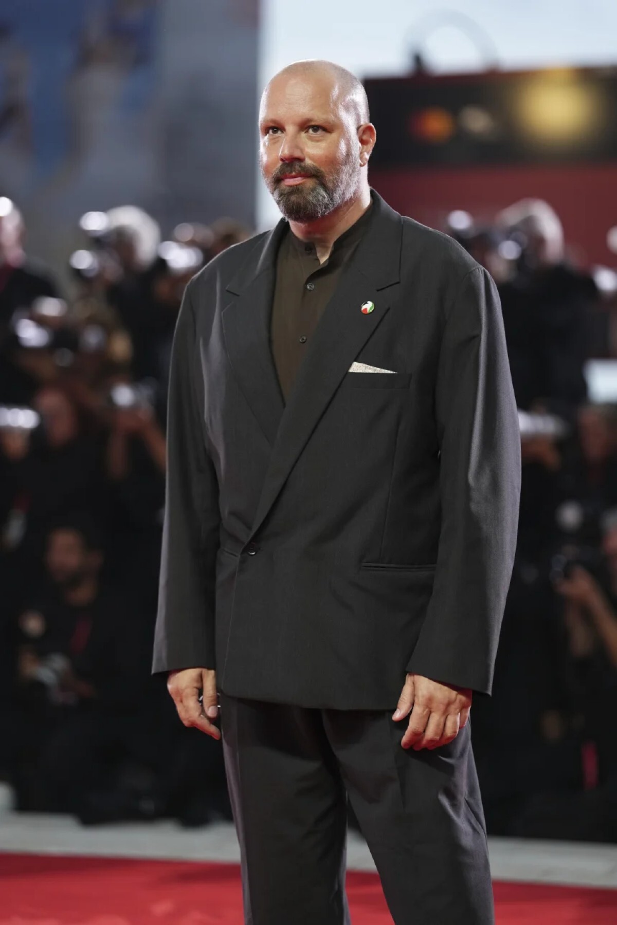 彫刻的なチャコールグレーのスーツと立て襟のシャツを着たヨルゴス・ランティモス監督/Scott A. Garfitt/Invision/AP