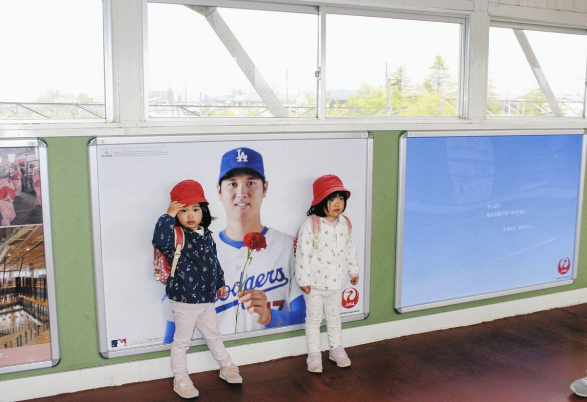 「母の日」に合わせてドジャースの大谷の故郷・岩手県・ＪＲ花巻駅に掲出された日本航空の限定広告と、記念撮影する子どもたち
