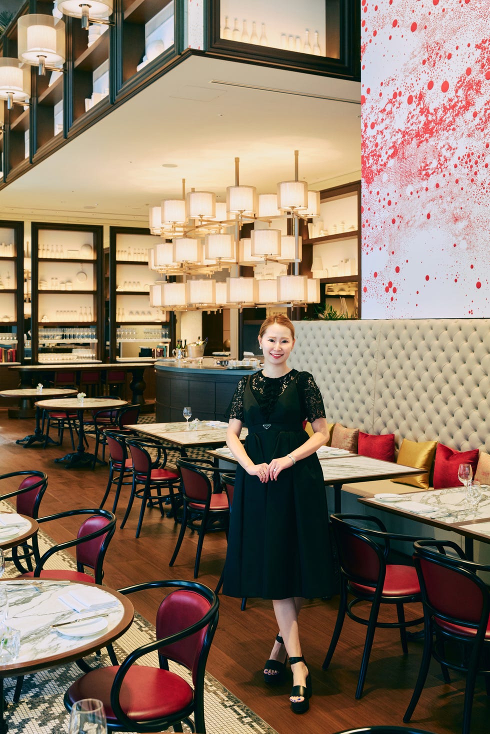 a woman stands in a restaurant with modern decor and a vibrant art piece a woman stands in a restaurant with modern decor and a vibrant art piece