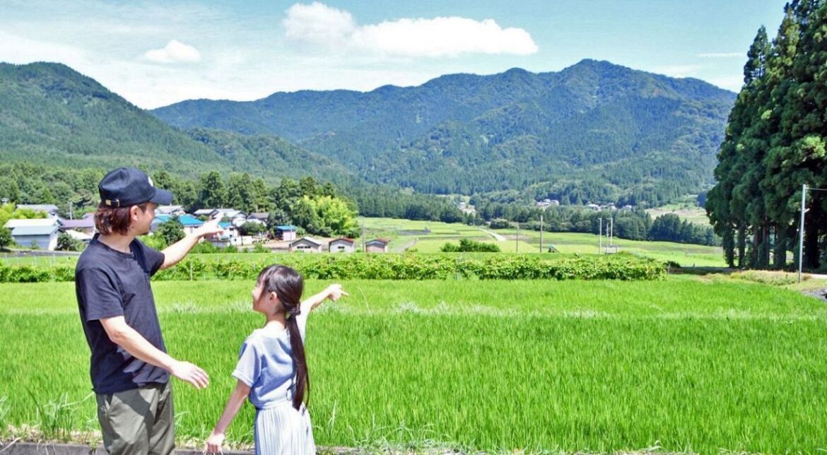 カバーアートが撮影されたとみられる場所を訪れて喜ぶ親子連れ＝大野市内で