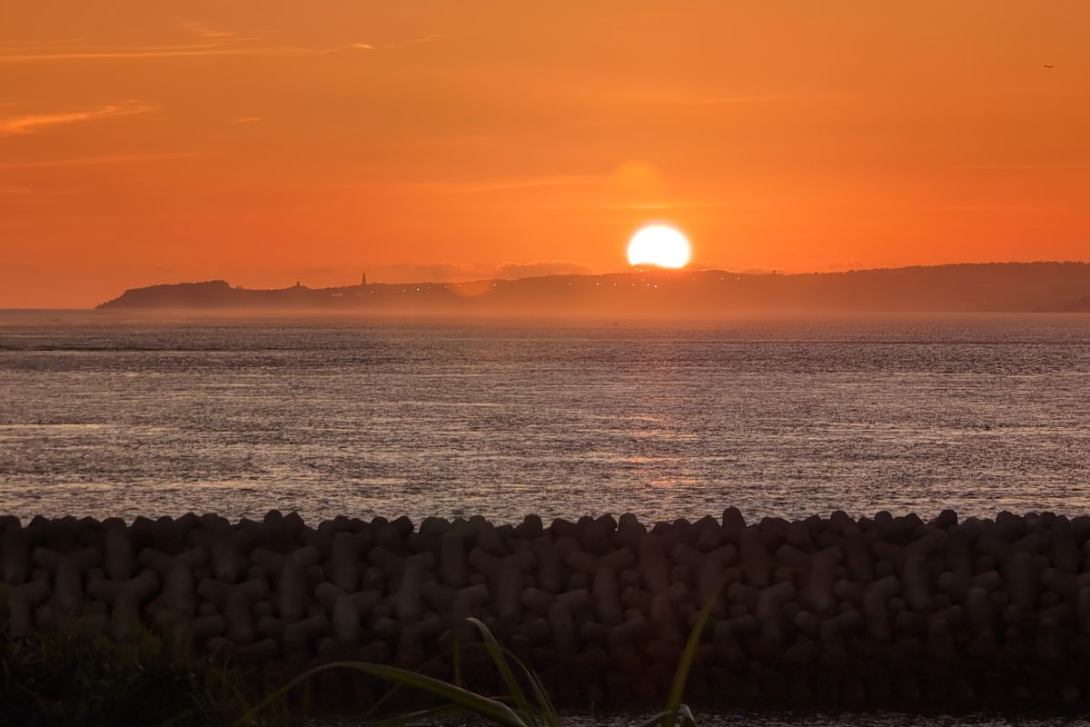 久高島から本島に向かって夕日が沈む光景