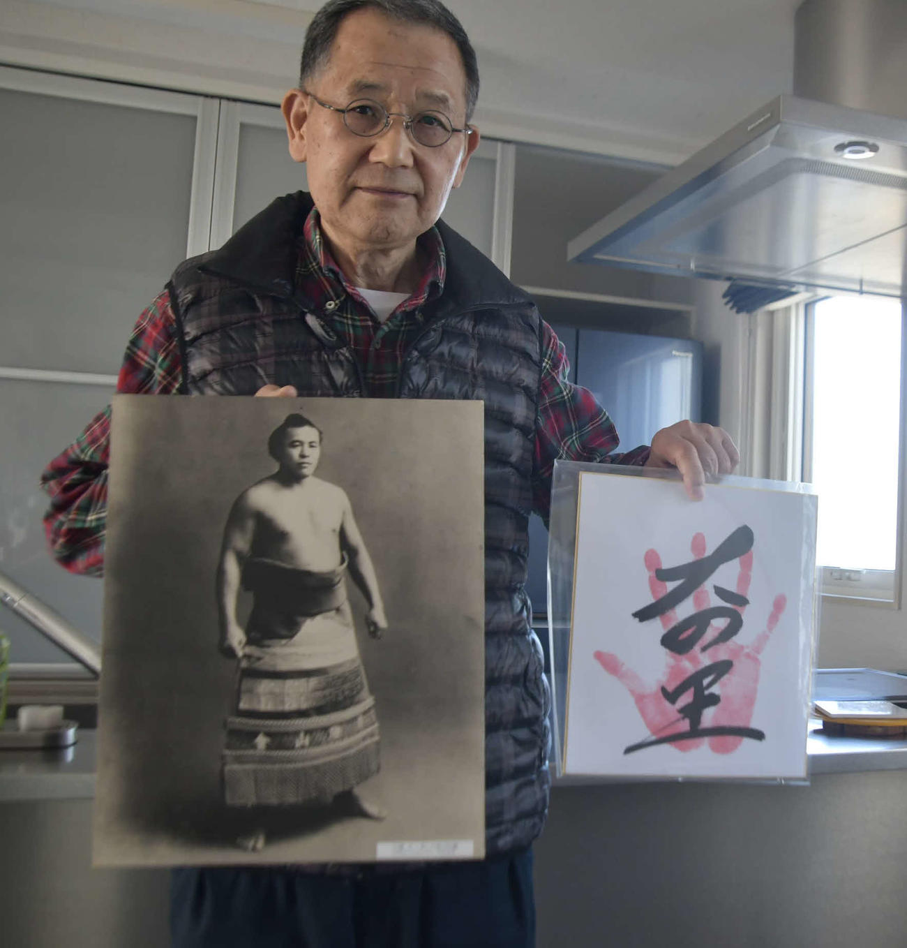 初代大ノ里の写真と2代目大の里の手形を持つ、初代大ノ里の一族の天内(あまない)司さん