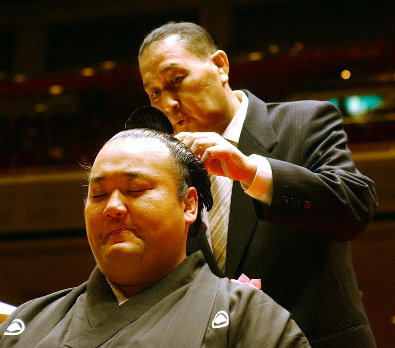 断髪式に臨んだ貴ノ浪は、涙をこらえながら二子山親方(元大関貴ノ花)にはさみを入れられる(2005年1月30日撮影)