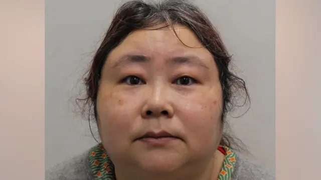 黒い髪を後ろでまとめた女性の正面からの写真