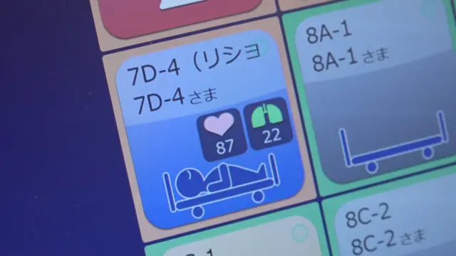 コンピューター画面に、ベッドで眠る人型のアイコンや心拍数（1分間に87回）、呼吸数（1分間に22回などが表示されている