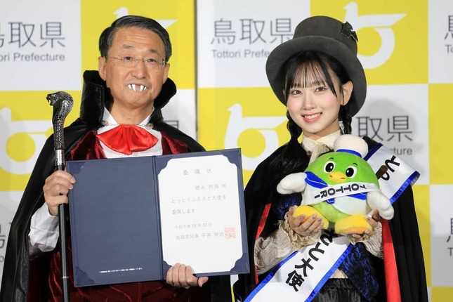 吸血鬼姿の鳥取県の平井伸治知事(左)とAKB48の鳥取出身メンバー、徳永羚海(れみ)さん(右)。「とっとりふるさと大使」の委嘱状と名刺が手渡された
