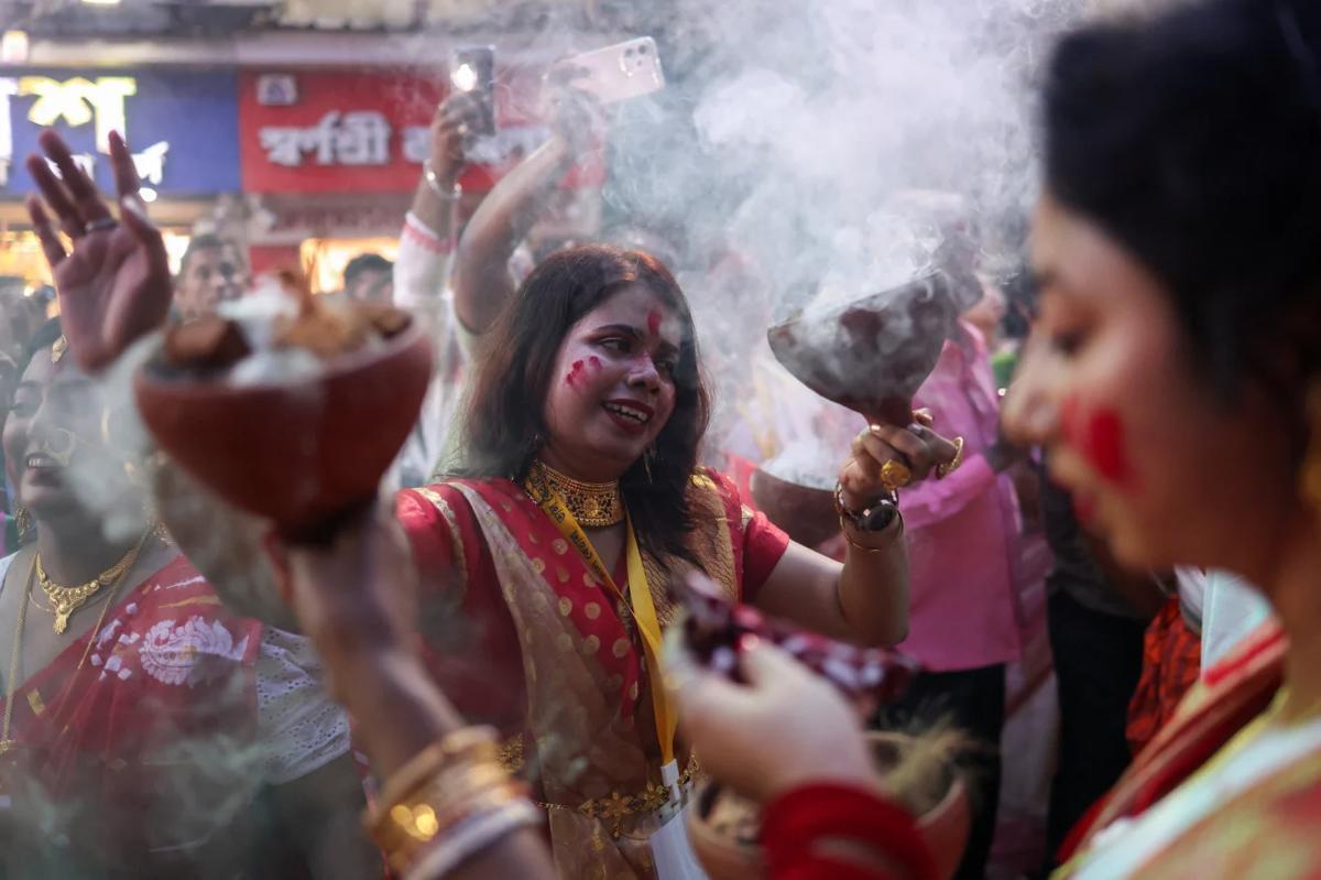 女神ドゥルガーの像の前で伝統的な踊りを披露する信者=3日、インド・コルカタ/Sahiba Chawdhary/Reuters