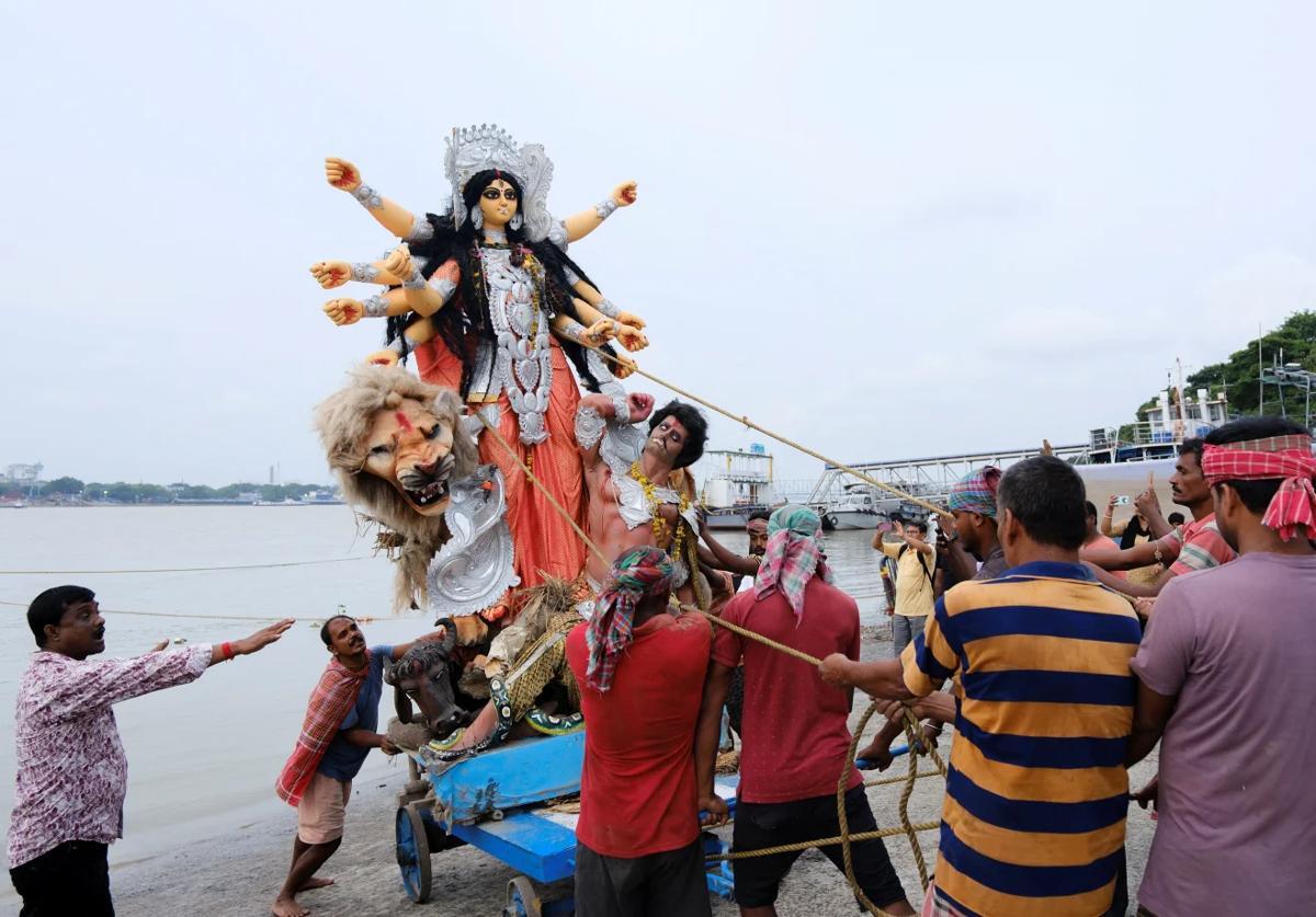 ヒンドゥー教の女神ドゥルガーの像がガンジス川に沈められて、祭りが終わりを迎える=4日/Sahiba Chawdhary/Reuters